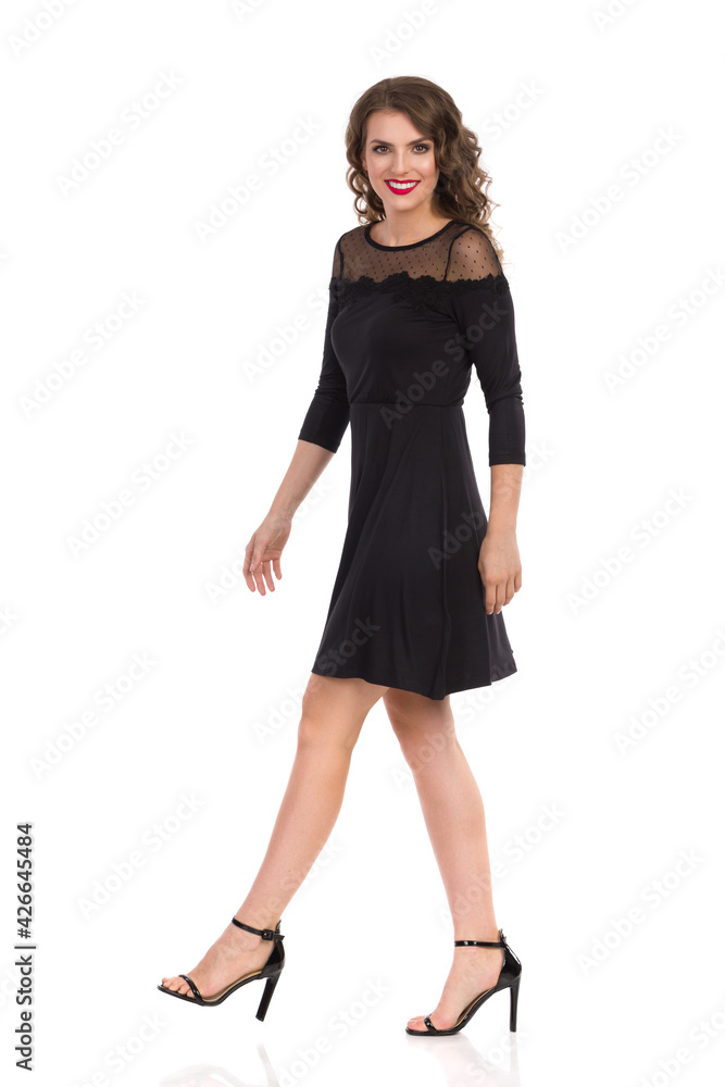 Walking Young Woman In Elegant Black Dress And High Heels. Walking Young Woman In Elegant Black Dress And High Heels.