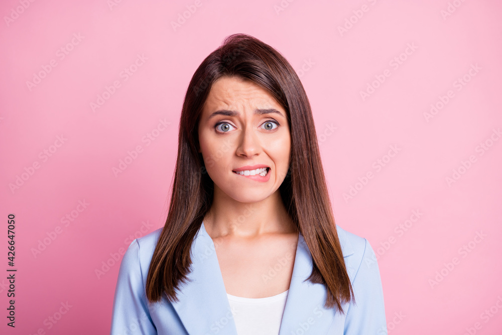 Portrait of stressed pretty brunette lady bite lips wear formal blazer isolated on pastel pink color background Portrait of stressed pretty brunette lady bite lips wear formal blazer isolated on pastel pink color background