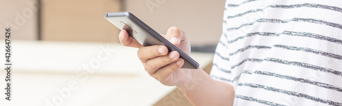 Hand holding and using smartphone.