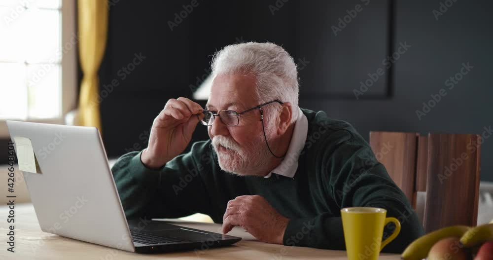 Older man looking at laptop screen rejoicing winning lottery. Portrait of aged happy grandfather clapping hands and enjoying good news on computer Older man looking at laptop screen rejoicing winning lottery. Portrait of aged happy grandfather clapping hands and enjoying good news on computer