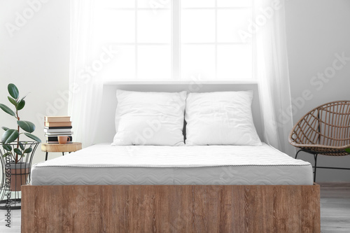 Soft orthopedic mattress on bed in room photo