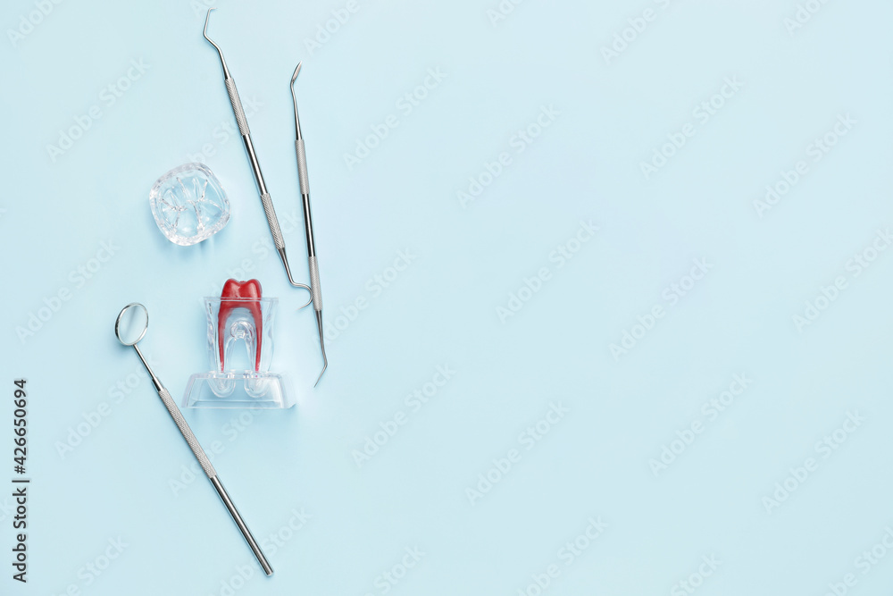 Dentist's tools and model of tooth on color background Dentist's tools and model of tooth on color background