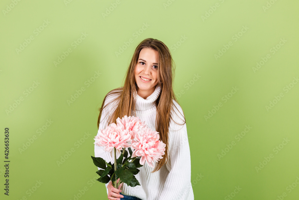 Pretty european woman in casual white sweater isolated on green background romantic look holding bouquet of pink flowers with smile Pretty european woman in casual white sweater isolated on green background romantic look holding bouquet of pink flowers with smile