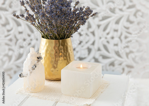 Using lavender for Feng shui purposes to promote happiness, wellbeing, good health in home environment. Selenite crystal candle holder and tower for removing negative energy from the body and mind. photo