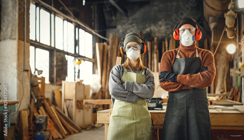 Woodworkers in protective masks and headphones