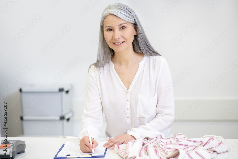 Good looking woman taking clothes for dry cleaning Good looking woman taking clothes for dry cleaning