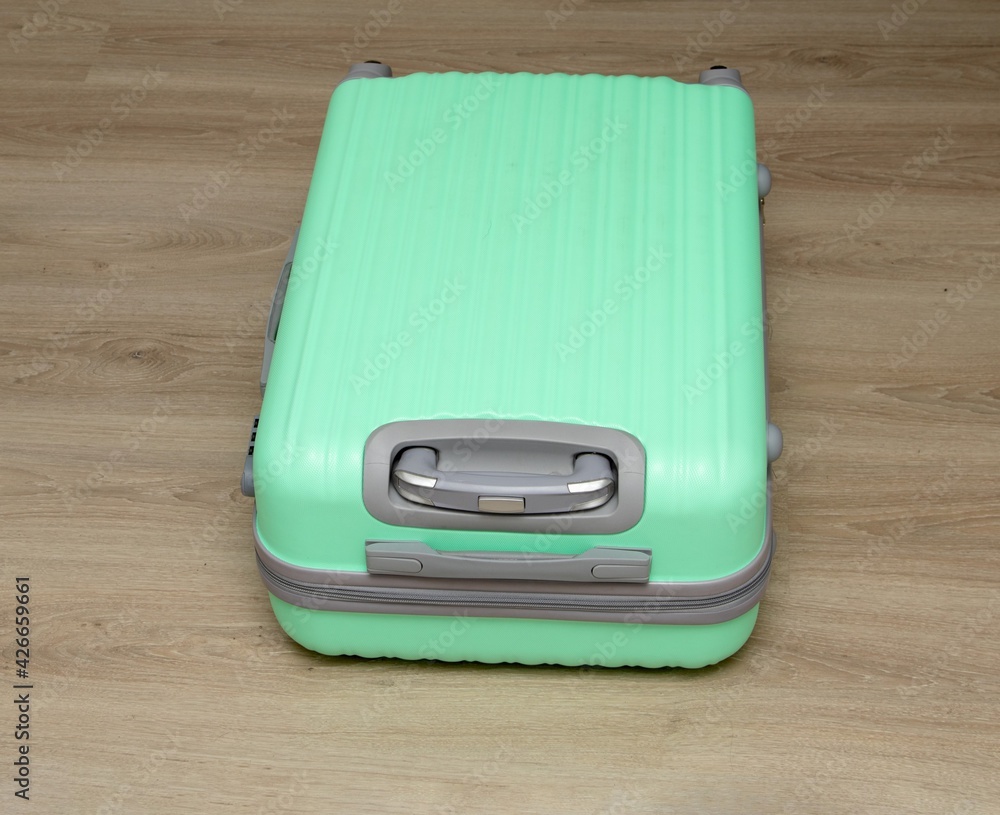 light green plastic suitcase on the floor light green plastic suitcase on the floor