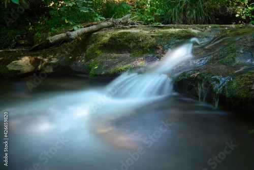 Fototapeta Naklejka Na Ścianę i Meble -  Ein kleiner Wasserfall mit aufgeschäumten Wasser