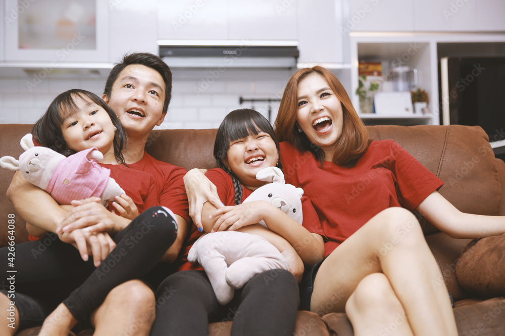 Young family watching TV together at home and having fun together Young family watching TV together at home and having fun together