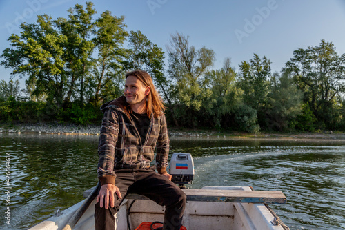 Chilled and pensive man riding boat on river © MexChriss