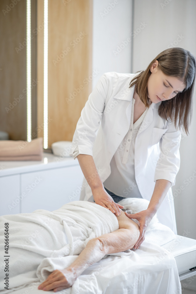 Female massage therapist working with a female senior patient Female massage therapist working with a female senior patient