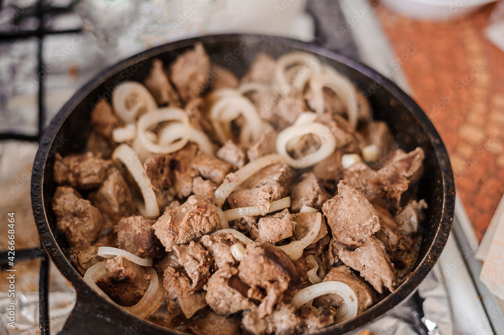 Fried veal liver with onions in a pan. Braised cow and pork liver Fried veal liver with onions in a pan. Braised cow and pork liver