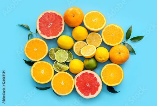 Fresh citrus fruits on color background