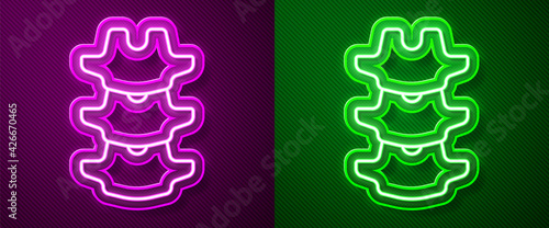 Glowing neon line Human spine icon isolated on purple and green background. Vector