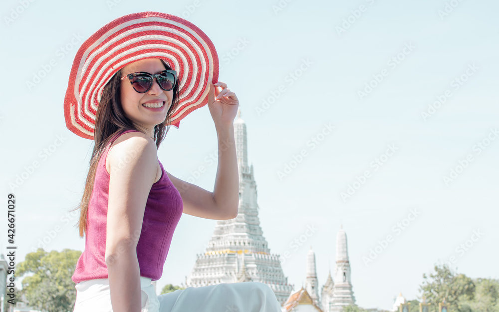 Fototapeta premium Woman wearing hat, sitting near river and travelling