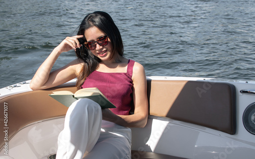 Woman reading book while sitting on boat