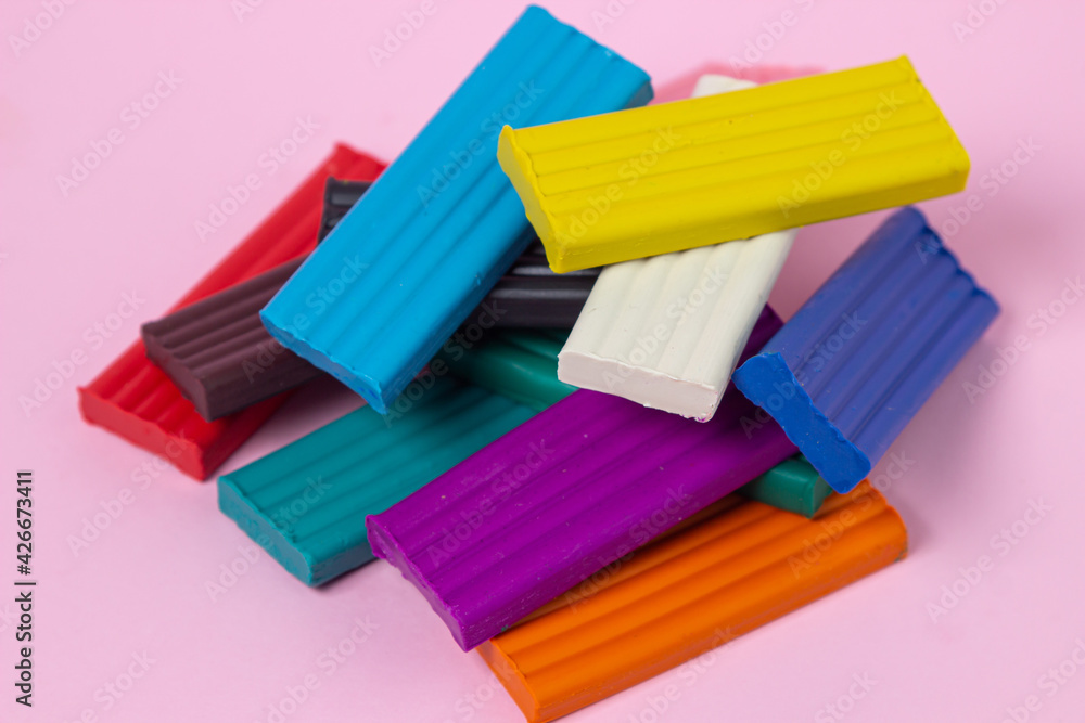 Multi-colored plasticine on a pink background. Educational game. Plasticine set Multi-colored plasticine on a pink background. Educational game. Plasticine set