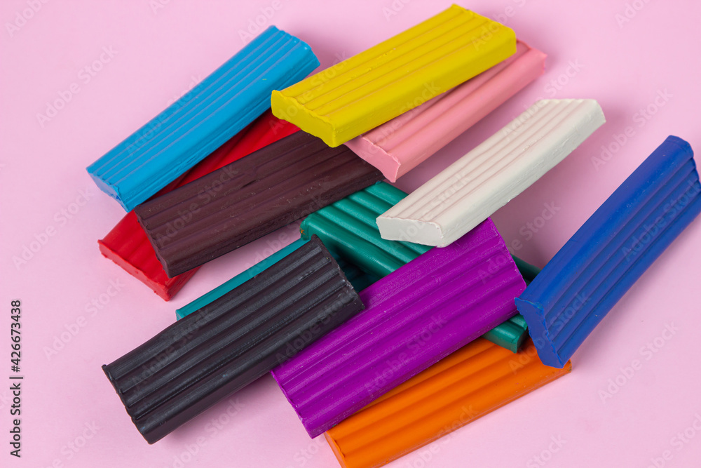 Multi-colored plasticine on a pink background. Educational game. Plasticine set Multi-colored plasticine on a pink background. Educational game. Plasticine set