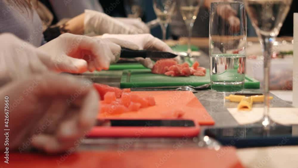 A group of people is slicing pieces of tuna. The concept of cooking courses. A group of people is slicing pieces of tuna. The concept of cooking courses.