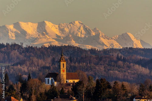kirchberg mit kirche vor den berner alpen im abendrot photo