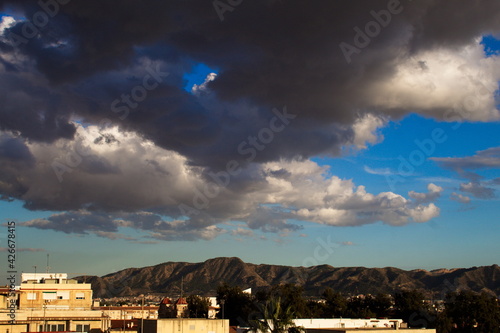 stunning clouds threatening rain over the city on a sunny sunset