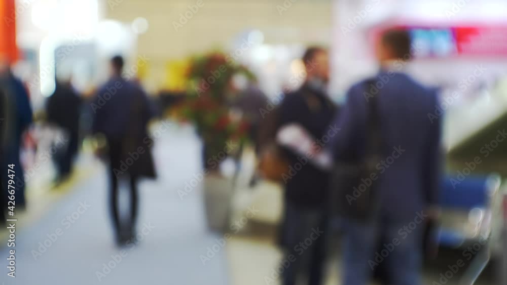 Many people inside a large bright hall inside the business center.Blurred background on a business theme. Many people inside a large bright hall inside the business center.Blurred background on a business theme.