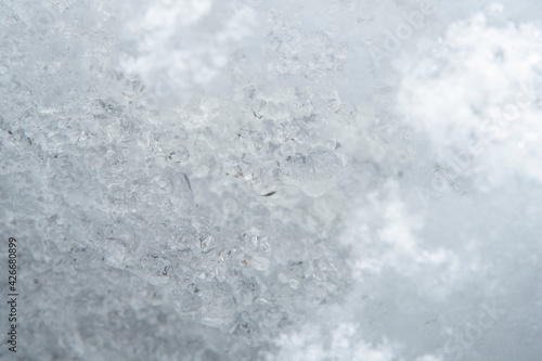 Background with close-up of snow under strong magnification. Slightly melted snow with sharp edges in soft focus.