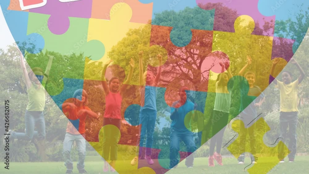 Animation of puzzles falling over heart formed with puzzles over school children jumping Animation of puzzles falling over heart formed with puzzles over school children jumping