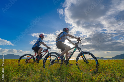 couple lover enjoy riding mountain bicyble adventure touring on the grass meadow at holidays weeken together exercise