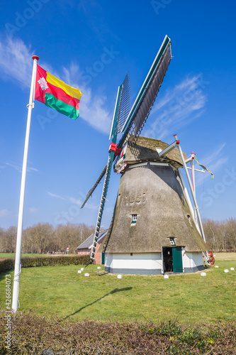 Tynaarlo flag in front of the historic windmill in Oudemolen, Netherlands
