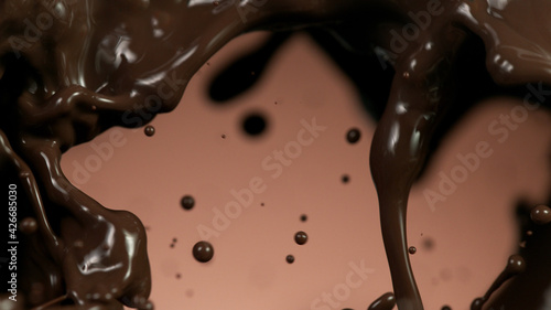 Splash of brownish hot chocolate on brown background.