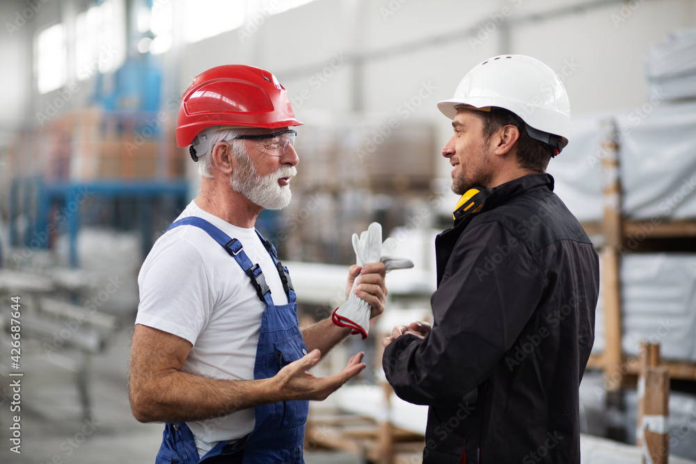 Portrait of workers in factory. Colleagues with helmet working in factory. Portrait of workers in factory. Colleagues with helmet working in factory.