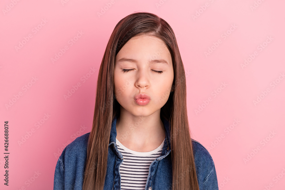 Photo portrait of wearing jeans jacket schoolgirl pouted lips sending air kiss isolated on pastel pink color background Photo portrait of wearing jeans jacket schoolgirl pouted lips sending air kiss isolated on pastel pink color background