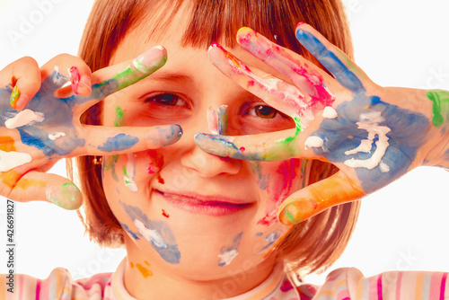 Art and fun leisure time concept. Humorous portrait of beautiful young child girl with colorful painted hands. Funny facial expression. Close up.