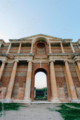 Фотография Low wide angle view of The main gate of the Greek Gymnasion-bath complex at the ancient city of Sardis under clear sky