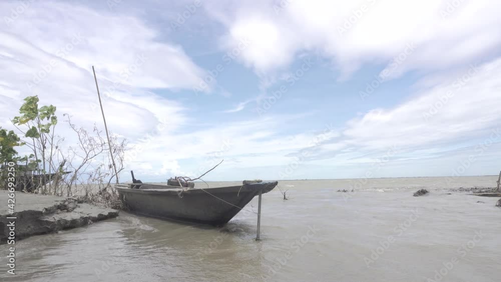 A boat is floating in the river while the river is experiencing erosion.