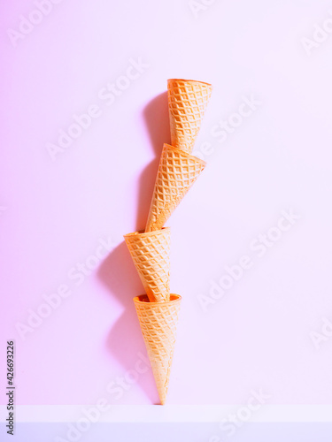 Waffle Sweet ice cream cones. Bouquet of waffle cups on a white shelf, levitation © byallasaa