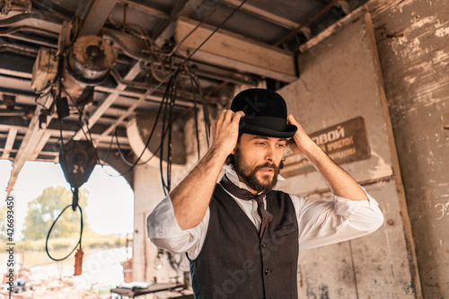 Steampunk. A hero on a river barge surrounded by steel mechanisms. A man with a weapon.