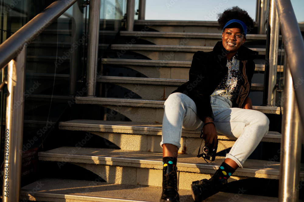 Young female traveler with camera. Beautiful african woman in the city. Young female traveler with camera. Beautiful african woman in the city.