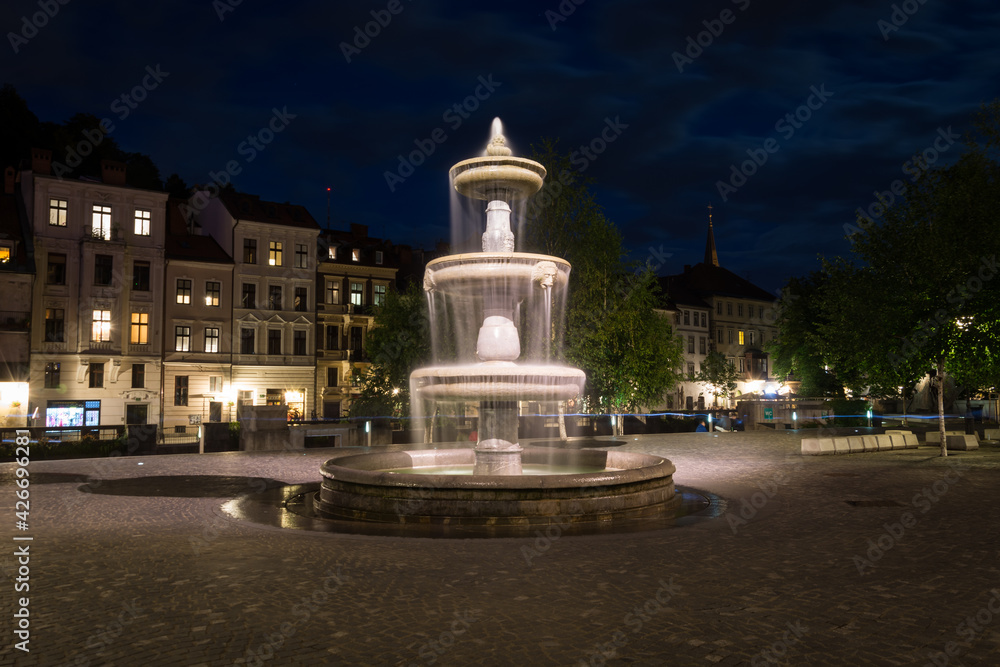 Ljubljana, Slovenia: fountain in the square in night. Empty streets in the city. Water flowing in beautiful concrete fountain
