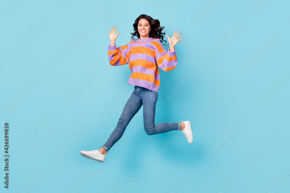 Full length body size view of attractive cheerful wavy-haired girl jumping running showing high five isolated over bright blue color background