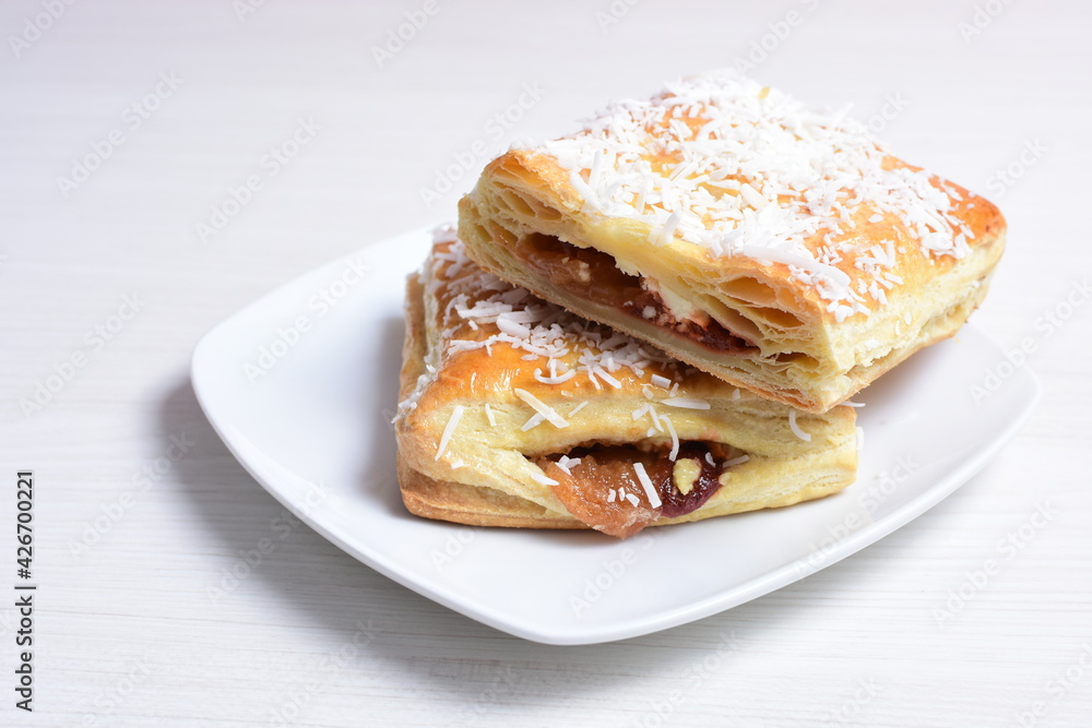Arequipe puff pastry displayed on white wooden background Arequipe puff pastry displayed on white wooden background