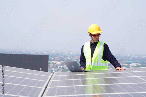 Asian engineer for solar panel inspection roof construction. Engineer worker installing solar panels outdoors