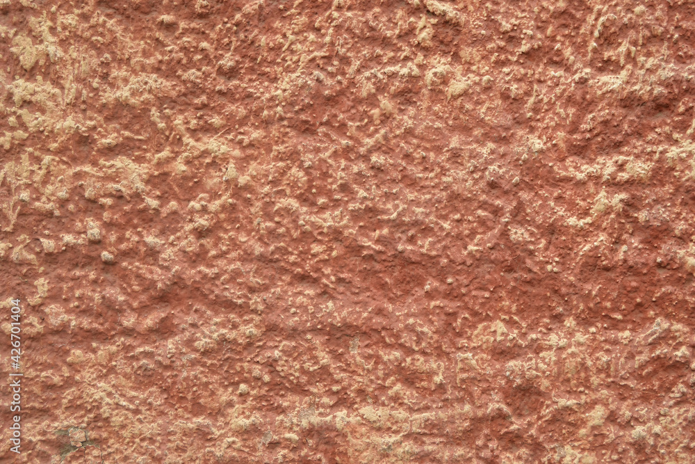 Red-orange painted wall with cinder block texture. Abstract interior background.