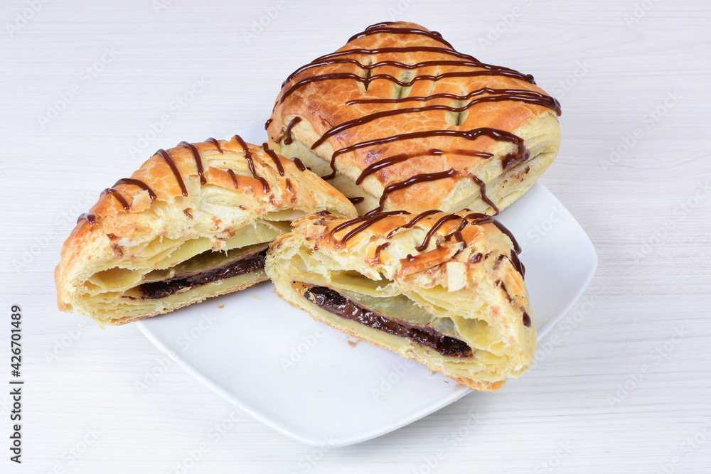 Chocolate puff pastry displayed on white wooden background Chocolate puff pastry displayed on white wooden background
