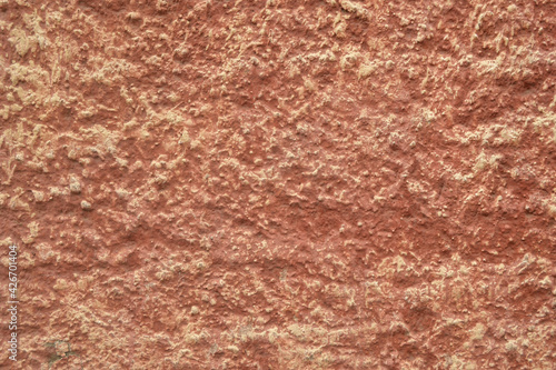 Red-orange painted wall with cinder block texture. Abstract interior background.