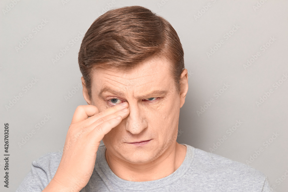 Portrait of serious thoughtful mature man rubbing his eye with hand Portrait of serious thoughtful mature man rubbing his eye with hand