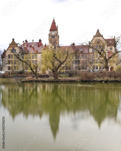 WROCLAW, POLAND - MARCH 28, 2021: A pond in the park and the building of the Faculty of Architecture of the Wroclaw University of Technology at Boleslaw Prus Street in Wroclaw, Poland, Europe. photo