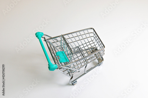 miniature shopping cart isolated on light background
