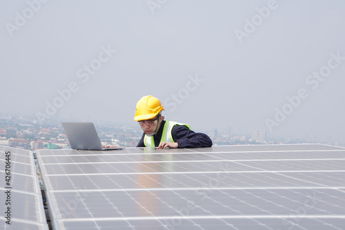 Asian engineer for solar panel inspection roof construction. Engineer worker installing solar panels outdoors